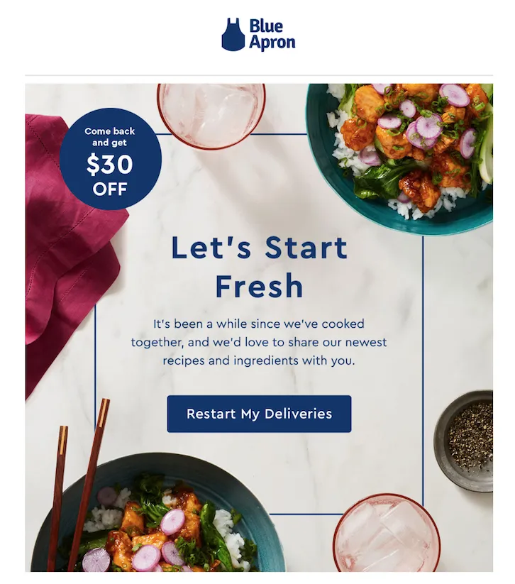 This is a screenshot from Blue Apron's winback program. The image shows a bird's eye view of a table set with a tablecloth, chopsticks, food, and various spices. In the foreground of the image, there is a patterned surface made of white and grey marble. The text "Let's start fresh" is displayed inside a thin blue frame and encourages the user to try Blue Apron's new recipes and ingredients. The call-to-action button reads "Restart my deliveries" and there is also a blue circle offering $30 off for returning customers.